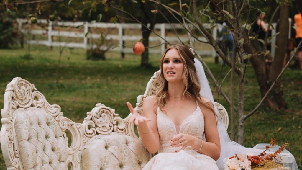 A bride outdoors, sitting on a couch.